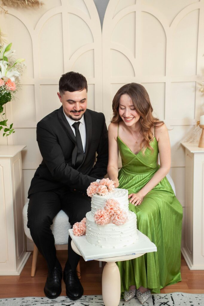 a couple is cutting their wedding anniversary cake